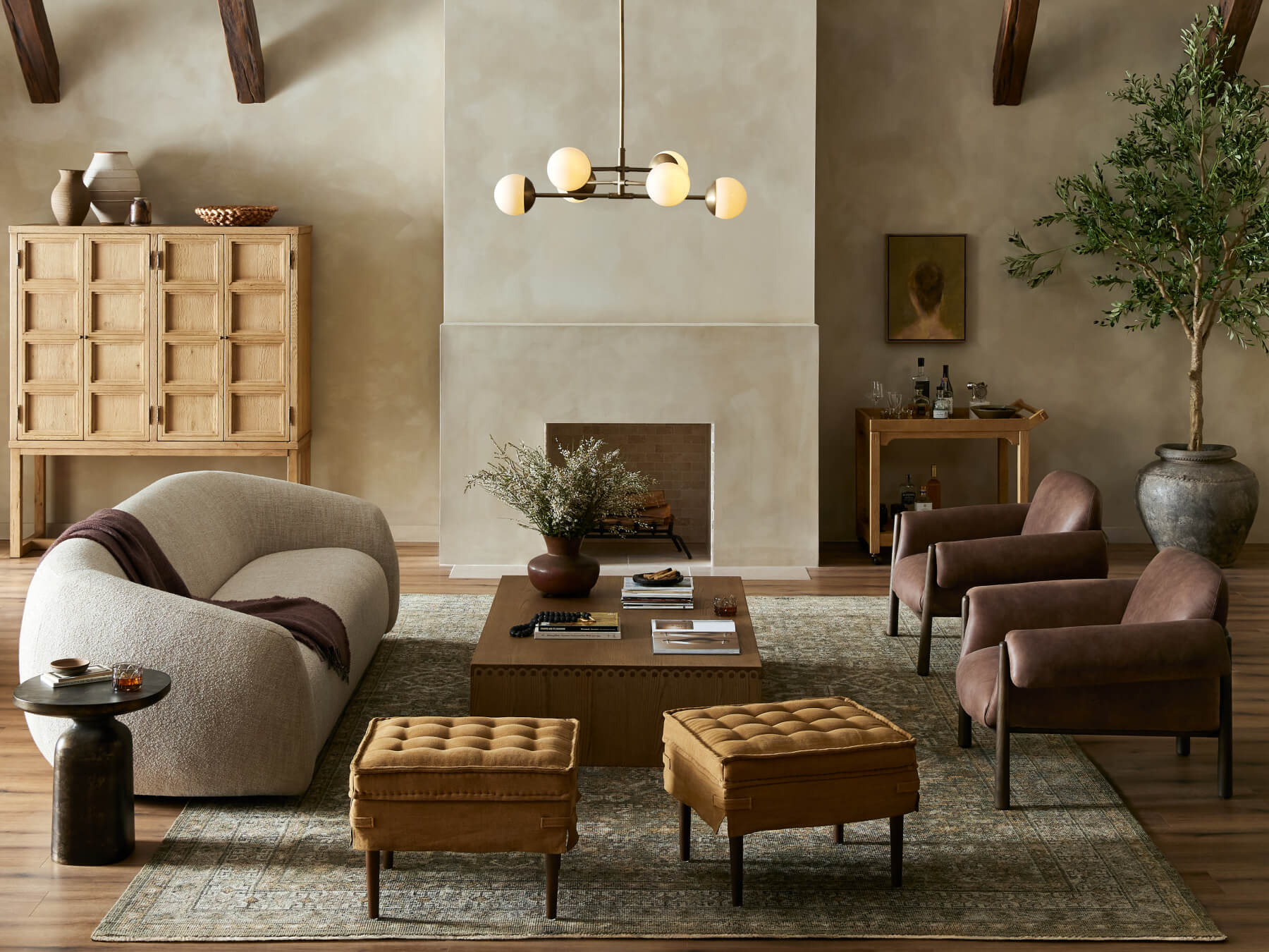 Four Hands living room with a curved cream sofa, brown lounge chairs and a wood coffee table.